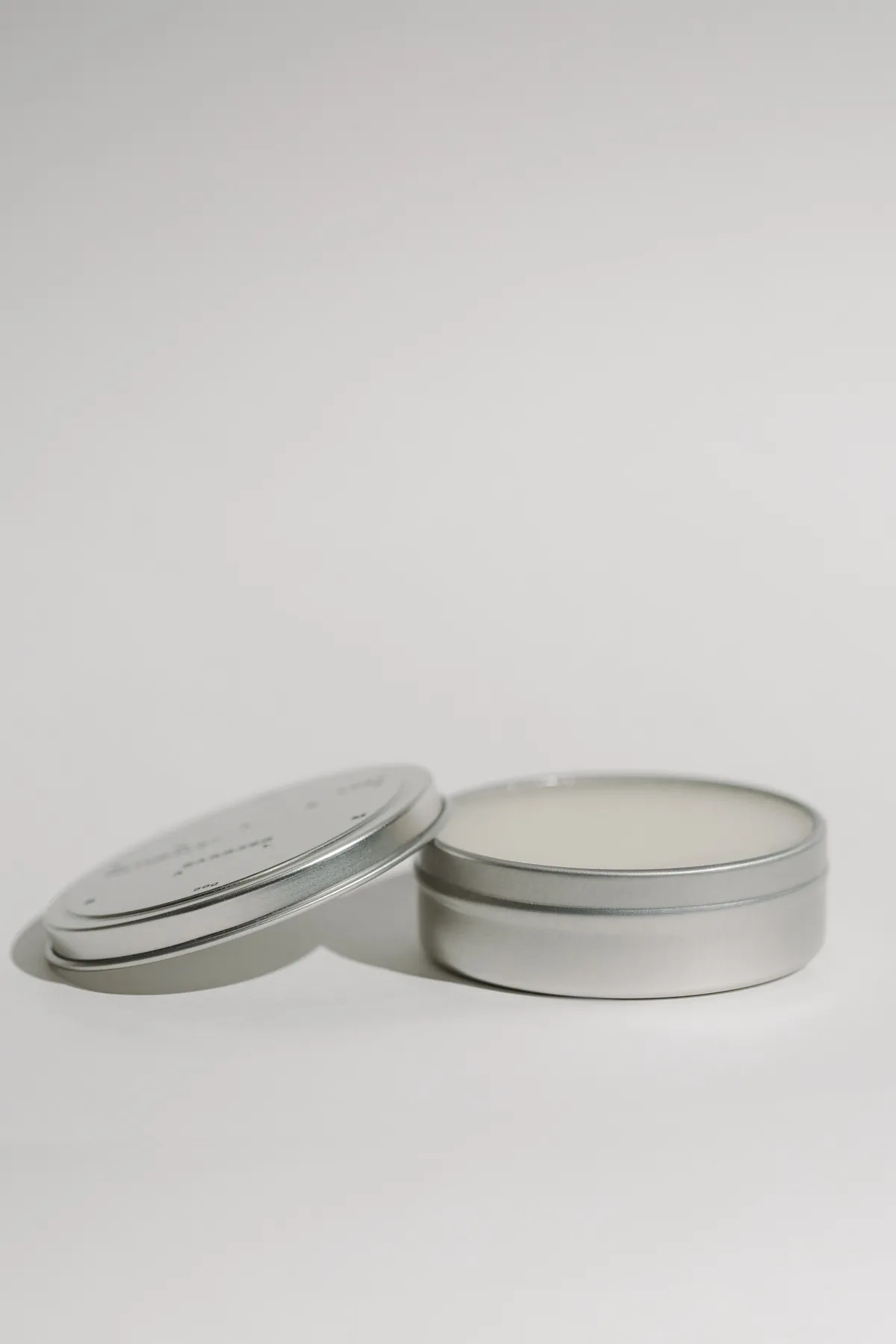The Barrier Balm tin, open with its lid resting alongside
