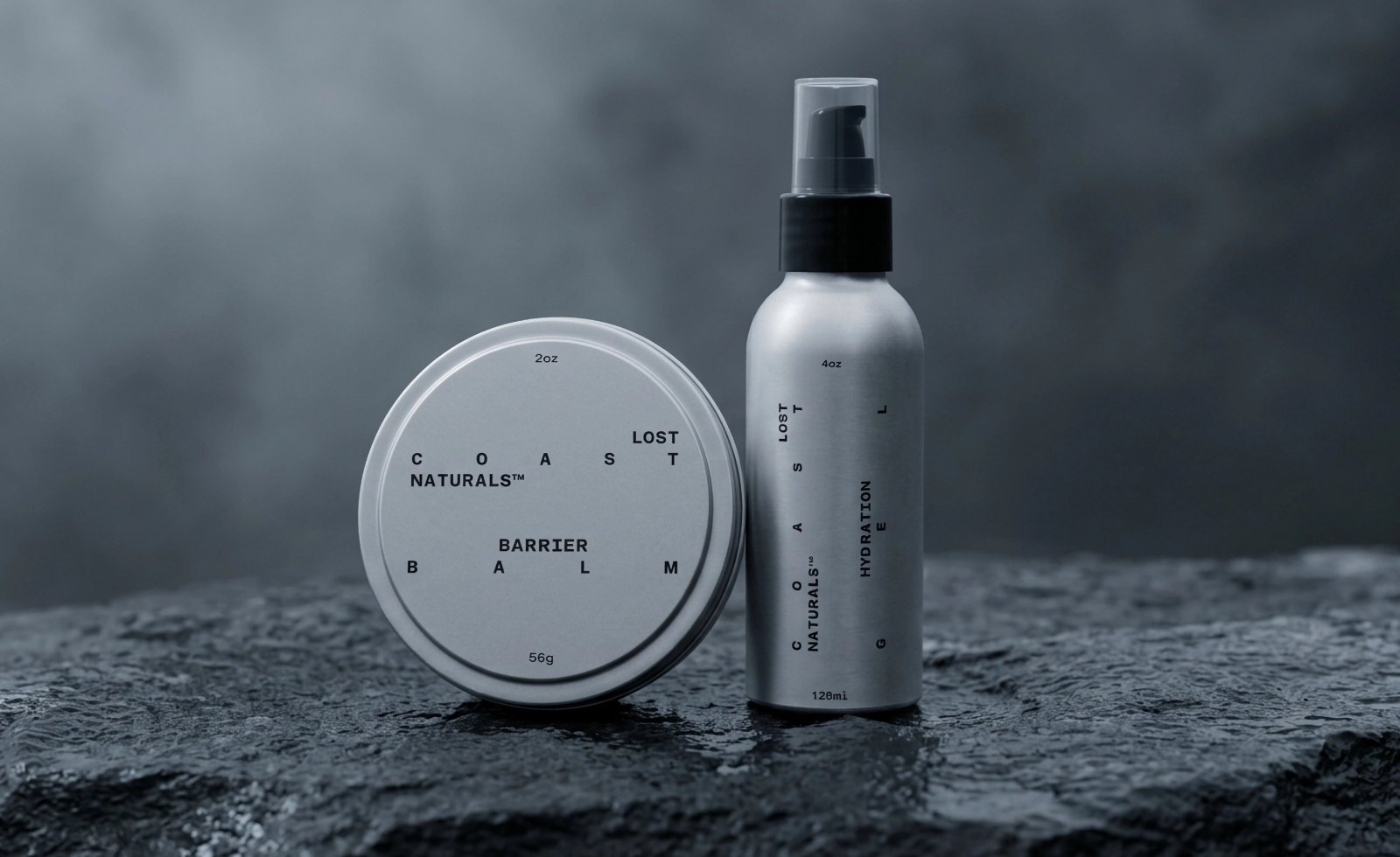 Lost Coast Naturals Barrier Balm and Hydration Gel resting on a wet rock against a foggy background
